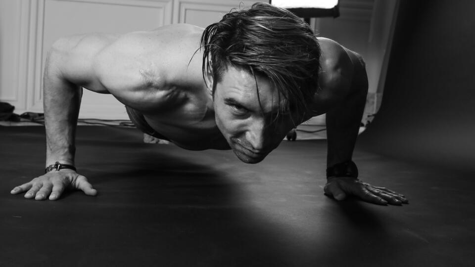 Muscular,Man,Doing,Push-ups,On,One,Hand,Against,Dark,Background.