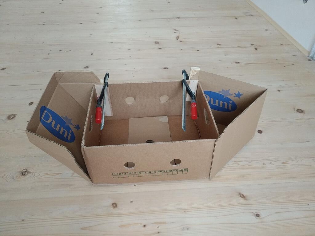 3. Z druhej časti krabice od topánok vyrobte zadnú časť – kormu. Jeden bok krabice bude tvoriť dno, druhý bok bude šikmo hore. Boky krabice odstrihnite podľa sklonu a aj túto časť prilepte k banánovej krabici.