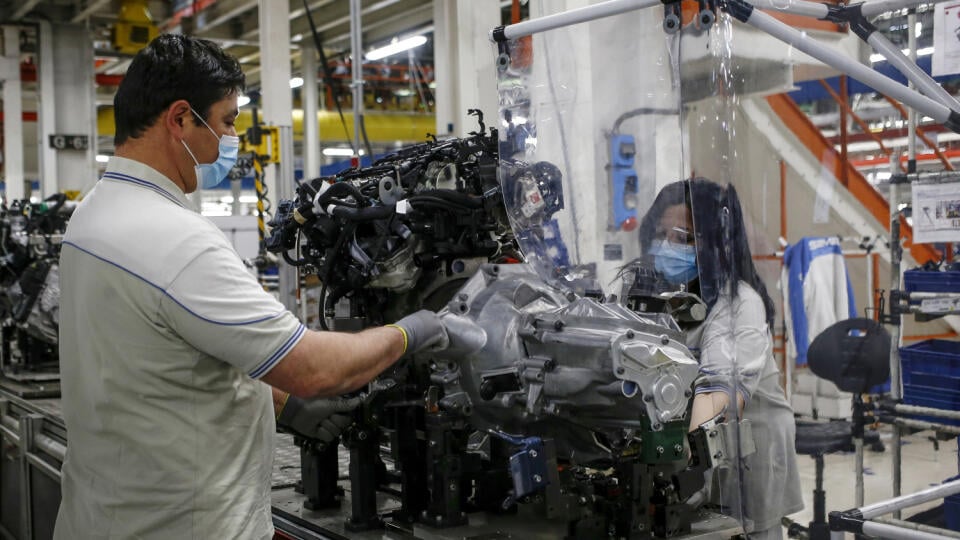 Zamestnanci s ochrannými rúškami počas práce v automobilke Fiat Chrysler Automobiles v Atese v Taliansku.