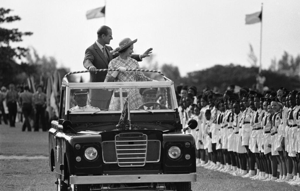 Na archívnej snímke z 15. októbra 1977 britská kráľovná Alžbeta II. a britský princ Philip mávajú ľuďom po príchode do Nassau na Bahamách.