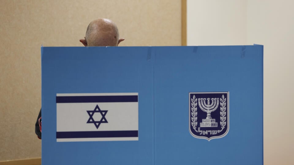 WA 1 Tel Aviv - Volič upravuje hlasovací lístok za plentou vo volebnej miestnosti v Tel Avive počas predčasných parlamentných volieb v Izraeli v utorok 1. novembra 2022. Izraelčania v utorok hlasujú v predčasných parlamentných voľbách, v ktorých sa bývalý premiér Benjamin Netanjahu usiluje o návrat k moci. Utorkové voľby – piate od apríla roku 2019 – boli vypísané po júnovom páde vlády vtedajšieho premiéra Naftaliho Bennetta, ktorého na tomto poste vystriedal Jair Lapid. FOTO TASR/AP
An Israe