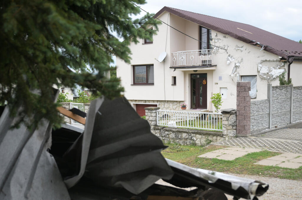 Na snímke rodinný dom (v pozadí), ktorý poškodila strhnutá strecha základnej školy v dôsledku silného vetra a dažďa v obci Ďurkov v okrese Košice – okolie vo štvrtok 10. júla 2025. FOTO TASR – František Iván

