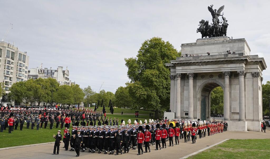 Na snímke rakva s pozostatkami zosnulej britskej kráľovnej Alžbety II., položená na štátnej lafete kráľovského námorníctva ťahanej námorníkmi, počas smútočného sprievodu popod Wellingtonov oblúk v Londýne v pondelok 19. septembra 2022.