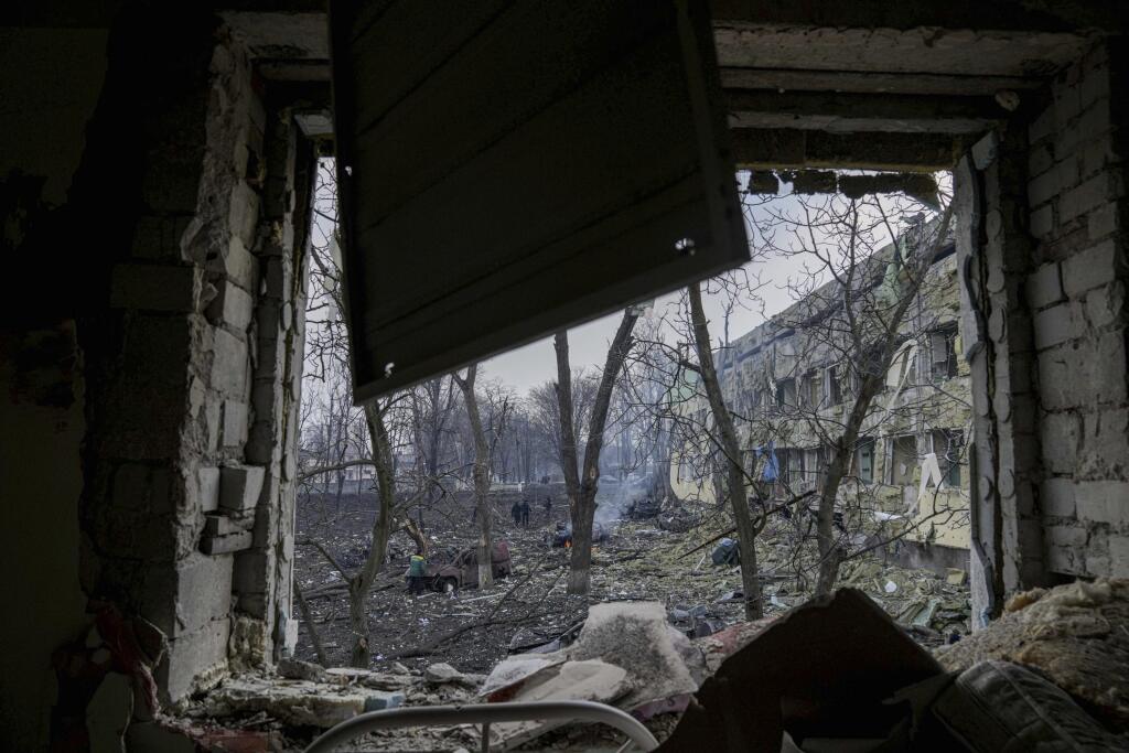 KK33 Mariupol - Na snímke budova detskej nemocnice po ostreľovaní v Mariupole počas štrnásteho dňa ruskej invázie na Ukrajine v stredu 9. marca 2022. Ruská armáda pri stredajšom ostreľovaní ukrajinského mesta Mariupol zasiahla a zničila detskú nemocnicu a pôrodnicu, tvrdia miestni činitelia aj ukrajinský prezident Volodymyr Zelenskyj. TASR túto informáciu prevzala zo stanice Sky News. FOTO TASR/AP  

Ukrainian emergency employees work at the side of the damaged by shelling maternity hospital in 