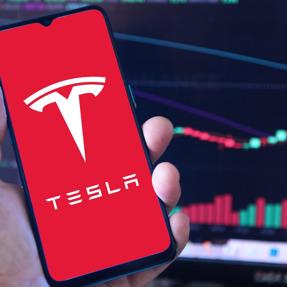 Tesla,Logo,On,Smartphone,Screen,With,A,Chart,Of,Stock