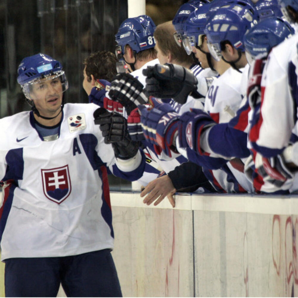 Slovakia's Peter Bondra, left, is congratulated at the bench after scoring his team's first goal against Kazakhstan during the second period of a 2006 Winter Olympics men's ice hockey game Sunday, Feb. 19, 2006, in Turin, Italy. (AP Photo/Christophe Ena)