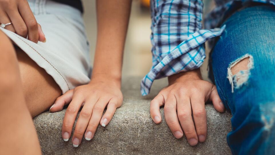 Hands of young couple in love close side by side on the first date