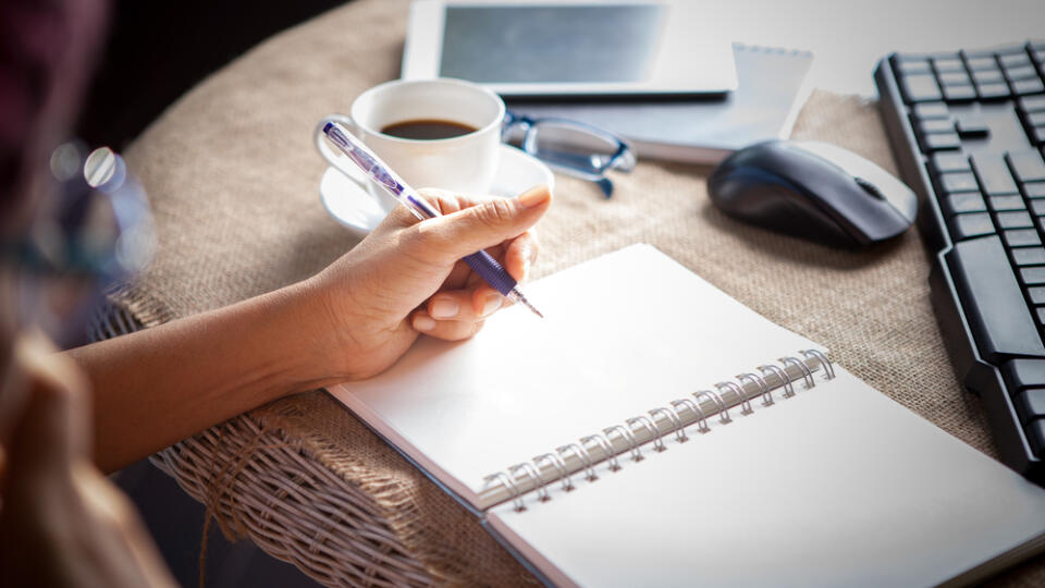 Woman,Left,Hand,Writing,On,Paper,Book,,on,Table,Shot