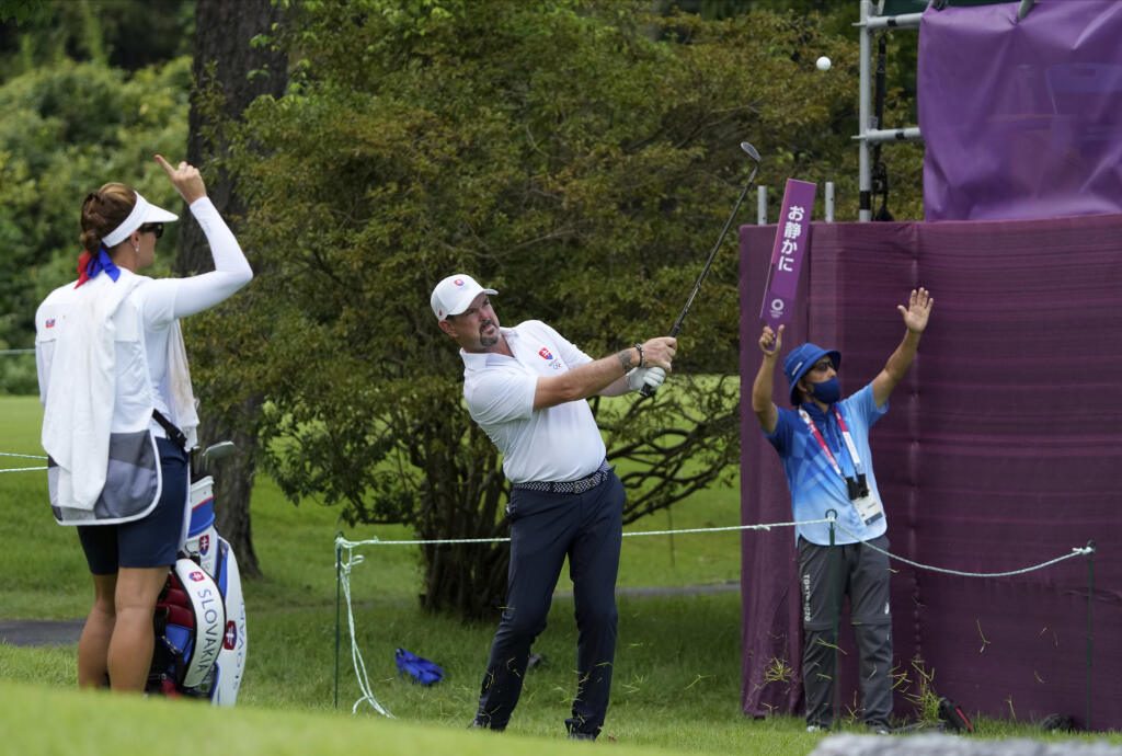 Na snímke uprostred slovenský reprezentant v golfe Rory Sabbatini, ktorého caddy je jeho manželka Martina Sabbatiniová (vľavo) v 2. kole turnaja na XXXII. letných OH v Tokiu 31. júla 2021. Sabbatini figuruje aj po sobotnom skompletizovaní programu 2. kola olympijského turnaja naďalej na priebežnom 11. mieste, na ktorom je spoločne s ďalšími tromi hráčmi.