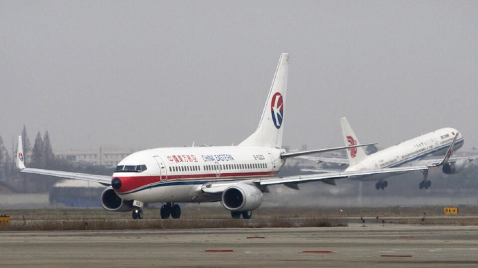 A China Eastern passenger airliner taxying on a runway while an Air China airliner take off at the Chengdu airport, southwest China's Sichuan province, Tuesday, Dec. 23, 2008. China Eastern Airlines plans to raise 7 billion yuan ($1 billion) from selling shares to its state-owned parent company _ more than double the amount originally planned _ to help it weather a financial crisis. (AP Photo/Andy Wong)