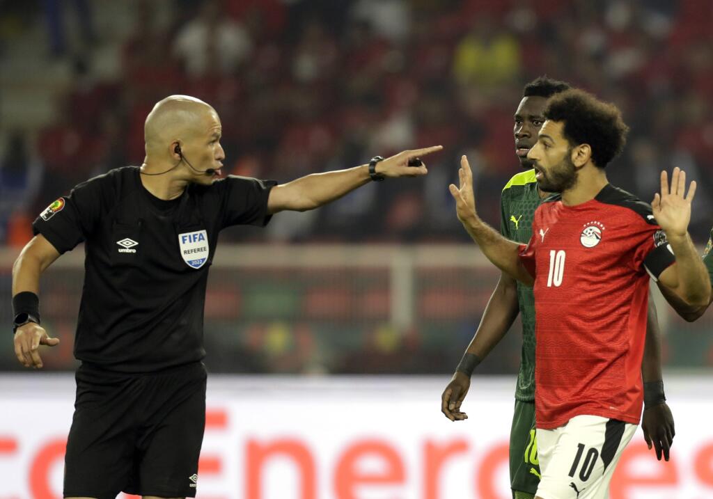 Na snímke vľavo hlavný rozhodca Victor Gomes a vpravo hráč Egypta Mohamed Salah diskutujú vo finále Afrického pohára národov vo futbale Senegal - Egypt v kamerunskom meste Yaoundé v nedeľu 6. februára 2022.