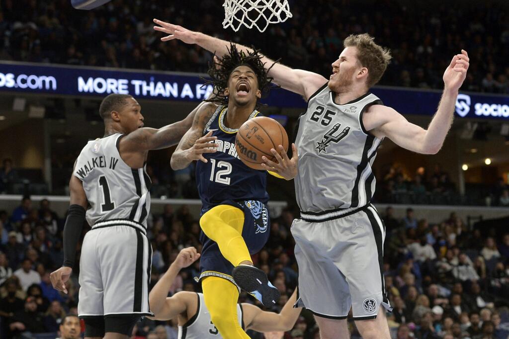 KK2 Memphis - Basketbalista Ja Morant (12) z Memphisu Grizzlies sa pokúša vystreliť cez dvojicu hráčov Lonnieho Walkera IV (1) a Jakoba Poeltla (25) počas zápasu zámorskej NBA 28. decembra 2022 v Memphise. FOTO TASR/AP
Memphis Grizzlies guard Ja Morant (12) jumps to shoot between San Antonio Spurs guard Lonnie Walker IV (1) and center Jakob Poeltl (25) during the second half of an NBA basketball game Monday, Feb. 28, 2022, in Memphis, Tenn. (AP Photo/Brandon Dill)