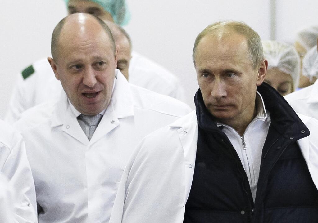 In this September 20, 2010 file photo, Russian businessman Yevgeny Prigozhin (left) and Russian President Vladimir Putin during a tour of his plant in St. Petersburg.