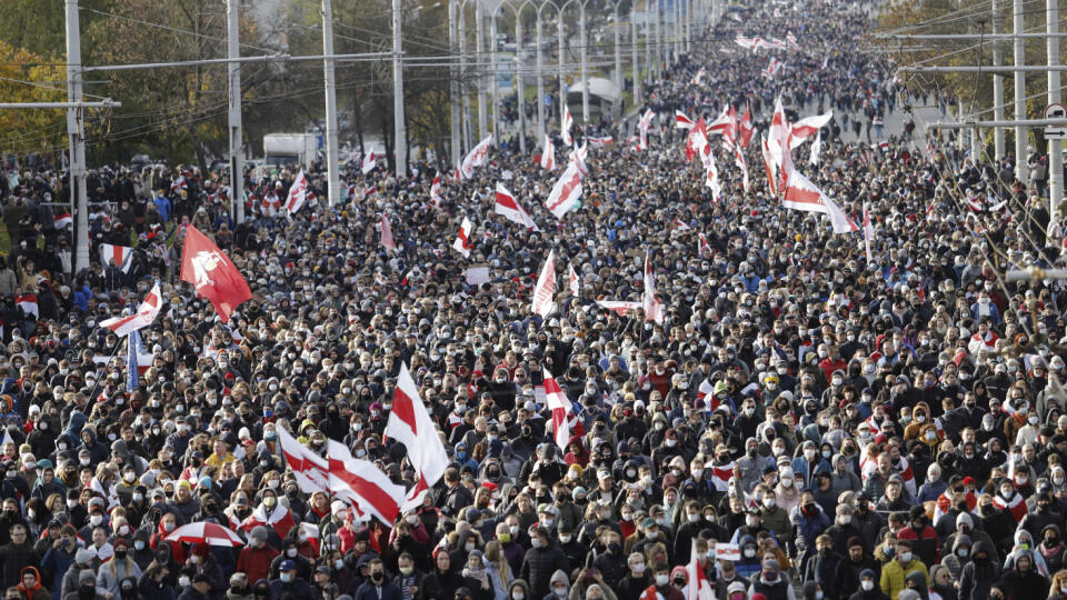 Na snímke ľudia so starými bieloruskými štátnymi vlajkami pochodujú počas zhromaždenia opozície na protest proti proti výsledkom augustových prezidentských volieb v bieloruskom Minsku.