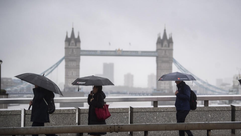 WA 4 Londýn - Ľudia kráčajú po moste London Bridge cez rieku Temža počas dažďa v stredu 21. októbra 2020.  Británia potvrdila v stredu 26.688 nových prípadov nákazy koronavírusom, čo predstavuje najvyšší denný prírastok v krajine od začiatku pandémie. Informovala o tom televízia Sky News s odvolaním sa na údaje britského rezortu zdravotníctva. FOTO TASR/AP 

Morning commuters cross the River Thames on London Bridge in central London, backdropped by Tower Bridge, as storm weather warnings are iss