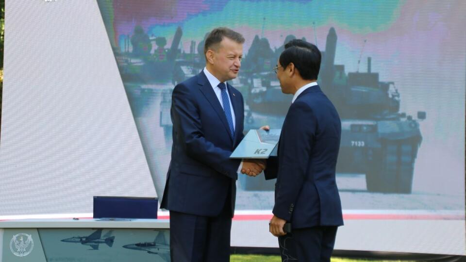 WA 12 Varšava - Poľský minister obrany Mariusz Blaszczak (vľavo) a výkonný riaditeľ spoločnosti Hyundai Rotem Co. Lee Jong-bä si podávajú ruky po podpise zmluvy na nákup zbraní vo Varšave v stredu 27. júla 2022. Poľsko podpísalo v stredu vo Varšave v rámci posilňovania obrany krajiny zmluvy na nákup juhokórejských zbraní vrátane tankov, delostrelectva a bojových stíhačiek. Počet zmlúv, ktoré boli podpísané na ceremónii so zástupcami spoločností Korea Aerospace Industries a Hyundai, konkretizovan