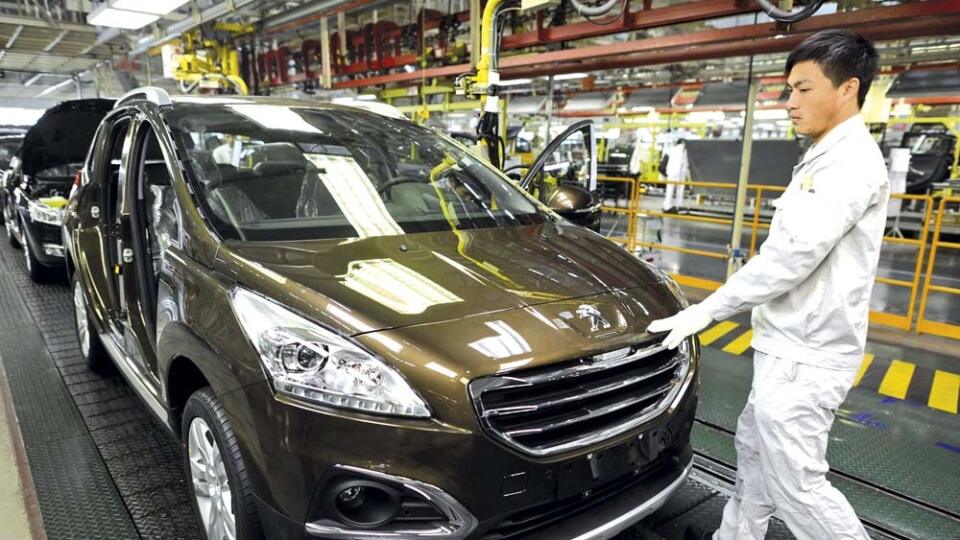 Image: 0184974934, License: Rights managed, Restrictions: CHINA OUT, This picture taken on December 7, 2013 shows a laborer working in the factory of Dongfeng Peugeot-Citroën Automobile Limited (DPCA) in Wuhan, central China's Hubei province. Chinese carmaker Dongfeng hopes its acquisition of a 1.1 billion USD stake in struggling French manufacturer PSA Peugeot Citroen will bring it a technology dividend and access to Western markets, but analysts said the road is likely to be long and bumpy.