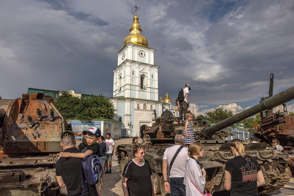 Bežný život v Kyjeve počas vojny: Na snímke si ľudia obzerajú zničené tanky na námestí v Kyjeve 12. júna 2022.