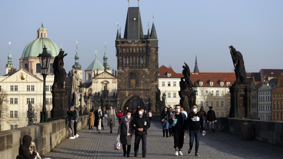 EBE 20 Praha - Na snímke ľudia s ochrannými rúškami sa prechádzajú po Karlovom moste v Prahe 25. februára 2021. V Česku bola v jednej vzorke potvrdená nákazlivejšia juhoafrická mutácia koronavírusu. Prvé podozrenia na prítomnosť juhoafrickej mutácie koronavírusu v Česku sa objavili pred troma dňami. Týkali sa trojice ľudí, ktorí sa vrátili zo Zanzibaru. Podozrenia sa objavili takisto v brnianskej materskej škole u dvoch detí a dvoch učiteliek. FOTO TASR/AP
People wearing face masks walk across t