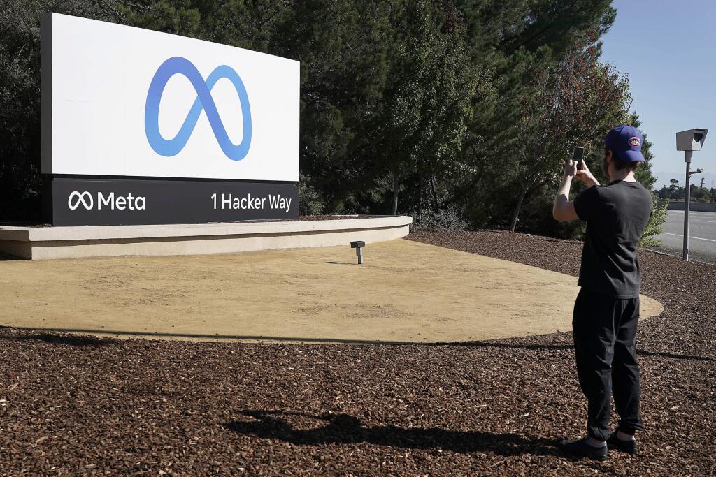 KK7 Menlo Park - Spoločnosť Facebook odhalila nové logo a nový názov Meta v sídle spoločnosti 28. októbra 2021 v Menlo Parku. Generálny riaditeľ americkej spoločnosti Facebook Mark Zuckerberg vo štvrtok oznámil, že jeho firma sa premenuje na Meta. Ide o súčasť jeho snahy obsiahnuť v názve spoločnosti svoju víziu virtuálnej reality pre budúcnosť, ktorú Zuckerberg nazýva metaverzum. FOTO TASR/AP 
Facebook employee take a photo in front of new Meta Platforms Inc. sign outside the company headquarte