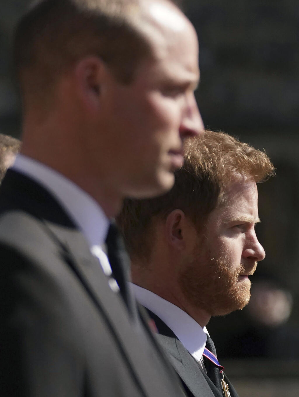 JB 82 Windsor - Zľava britský princ William a princ Harry sprevádzajú rakvu s telesnými pozostatkami britského princa Philipa pri prechádzaní okolo veže Round Tower počas pohrebu britského princa Philipa, manžela britskej kráľovnej Alžbety II., ktorý zomrel minulý piatok vo veku 99 rokov, v areáli Windsorského zámku vo Windsore 17. apríla 2021. Philipovo telo previezli zo súkromnej kaplnky pred vchod hradného areálu na špeciálne upravenom Land Roveri, ktorý pomohol navrhnúť sám princ. Odtiaľ sa