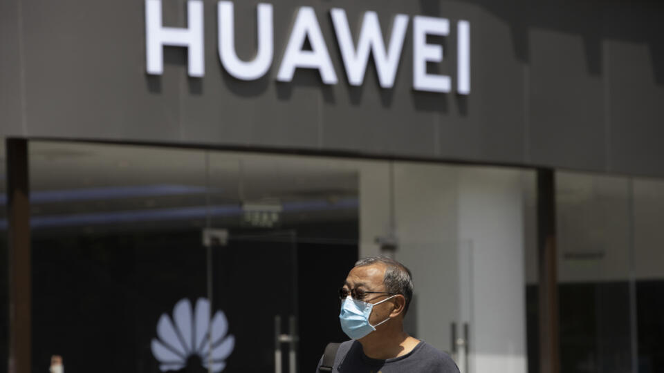 KK41 Peking - Muž s ochranným rúškom na tvári kráča okolo obchodu čínskeho gigantu Huawei 18. mája 2020 v Pekingu. Čínsky technologický gigant Huawei v pondelok označil najnovšie kroky USA, ktoré ho majú odrezať od dodávok polovodičov, za ničivý útok, ktorý spôsobí chaos v globálnom technologickom sektore a ďalších odvetviach. Americké ministerstvo obchodu v piatok (15.5.) oznámilo nové pravidlá. Tie zakazujú každému výrobcovi čipov, ktorý používa americké technológie alebo komponenty, dodávať i