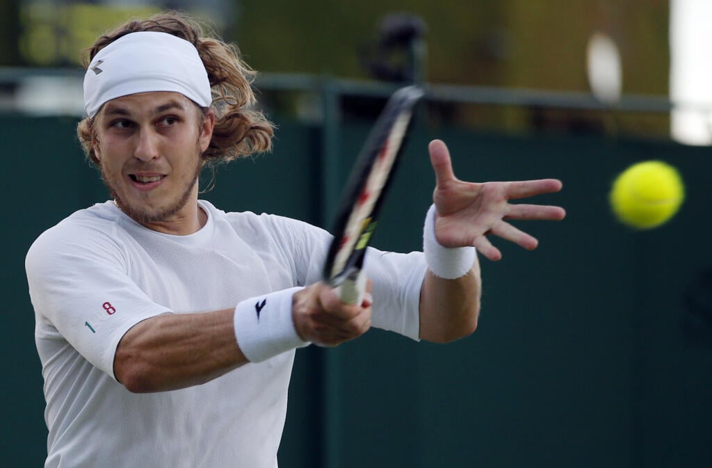 Slovenský tenista Lukáš Lacko odvracia loptičku Chorvátovi Marinovi Čiličovi v 2. kole tenisového turnaja Wimbledon v Londýne 1. júla 2016.