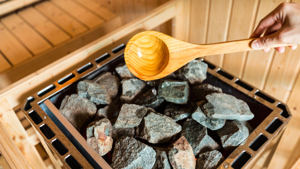 Woman,Is,Pouring,Water,Into,Hot,Stone,In,Sauna,Spa