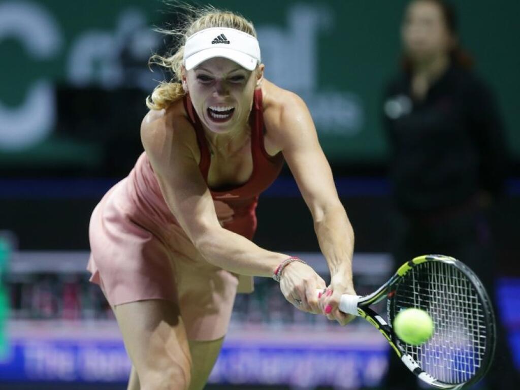 Denmark's Caroline Wozniacki makes a backhand return to Serena Williams of the US during their semifinal match at the WTA tennis finals in Singapore, Saturday, Oct. 25, 2014. (AP Photo/Mark Baker)