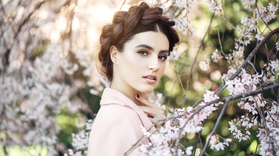 Beautiful girl on the background of spring bush