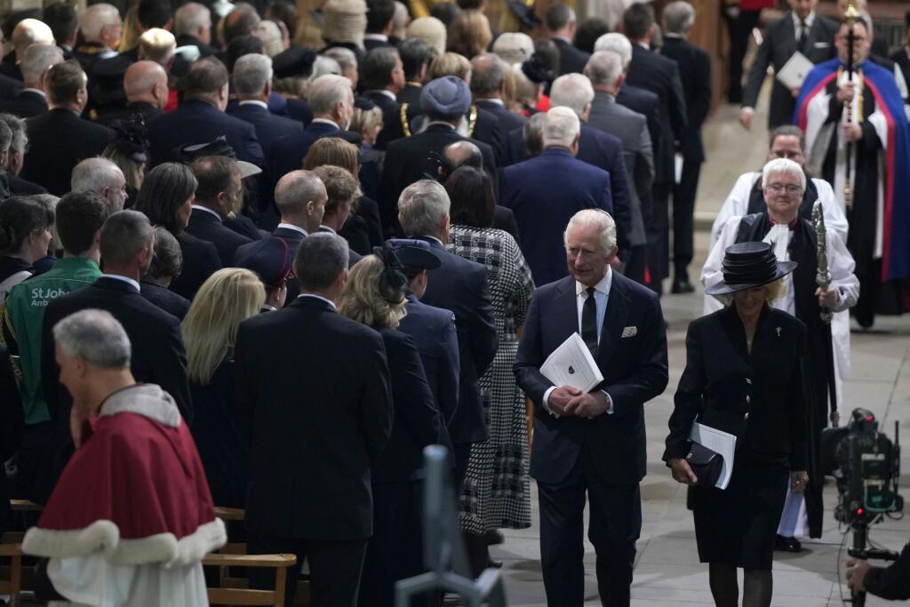 Britský kráľ Karol III. (uprostred) a Camilla, kráľovná manželka (vpravo) odchádzajú z katedrály Llandaff po bohoslužbe a modlitbe pre zosnulú britskú kráľovnú Alžbetu II. v Cardiffe vo Walese 16. septembra 2022.