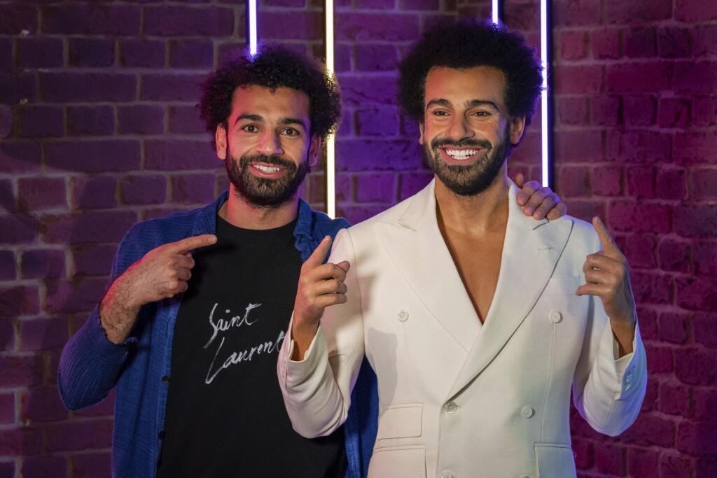 Na snímke vľavo egyptský útočník anglického futbalového klubu FC Liverpool Mohamed Salah pózuje vedľa svojej voskovej figuríny počas uvedenia v múzeu voskových figurín Madame Tussauds v Londýne 16. októbra 2021.