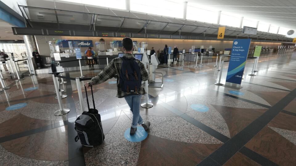 EBE 14 Denver - Na snímke cestujúci osamelý cestujúci čaká v piatok 24. decembra 2021 v Denveri pri odbavovacom pulte pre Alaska Airlines v termináli medzinárodného letiska v Denveri. Počas predĺženého vianočného víkendu bolo na celom svete zrušených približne 8300 letov a ďalšie desaťtisíce ich meškali. Rušenie letov najvýraznejšie postihlo Spojené štáty. Výpadky letovej dopravy spôsobilo predovšetkým šírenie vysokonákazlivého koronavírusového variantu omikron, keďže v dôsledku pozitívneho výsl