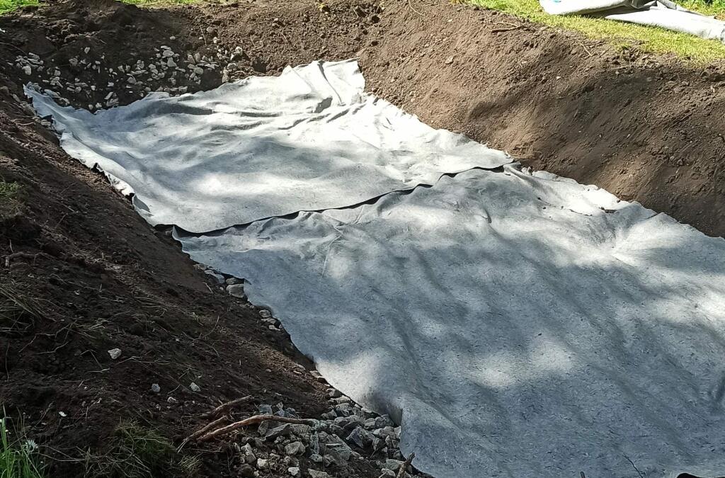 Na drenážnu vrstvu rozprestrite geotextíliu (300 g/m2), ktorá slúži ako separačná vrstva. Zabráni miešaniu jednotlivých vrstiev – úrodnej pôdy a kameniva.