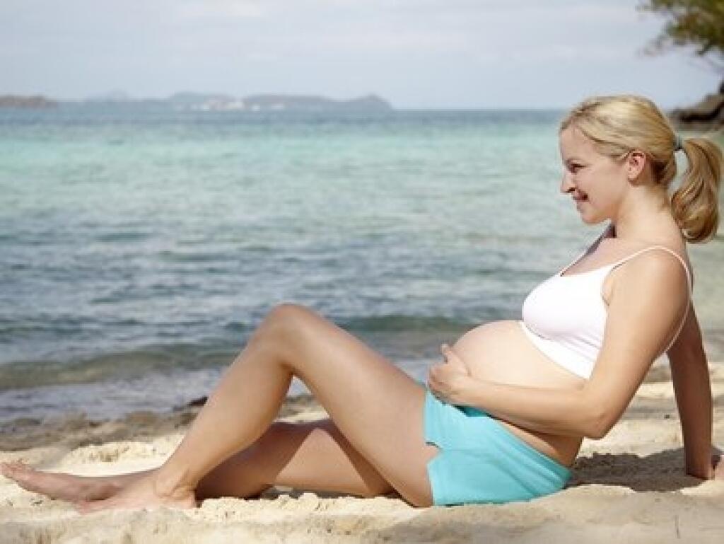 Беременная девушка на пляже
