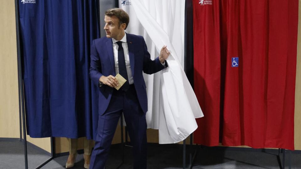 Francúzsky prezident Emmanuel Macron vychádza z priestoru na úpravu hlasovacích lístkov vo volebnej miestnosti počas hlasovania v prvom kole parlamentných volieb vo Francúzsku 12. júna 2022 vo francúzskom Le Touquet.