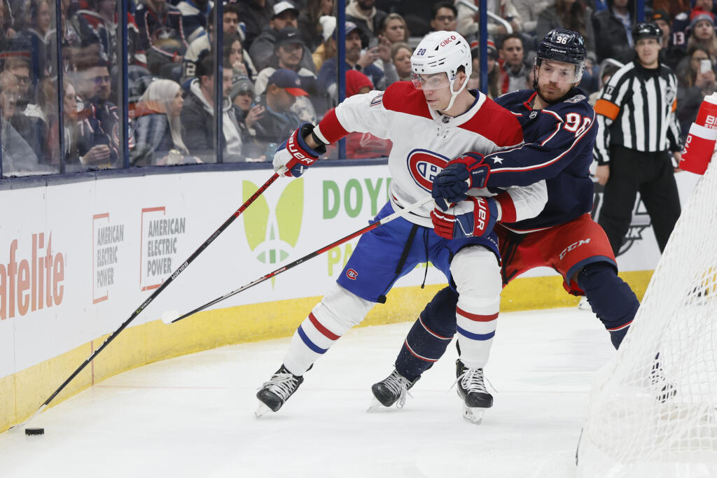 Slovenský hokejista Montrealu Canadiens Juraj Slafkovský (vľavo) a hráč Columbusu Blue Jackets Jack Roslovic bojujú o puk v zápase zámorskej hokejovej NHL Montreal Canadiens - Columbusu Blue Jackets v Columbuse vo štvrtok 17. novembra 2022.