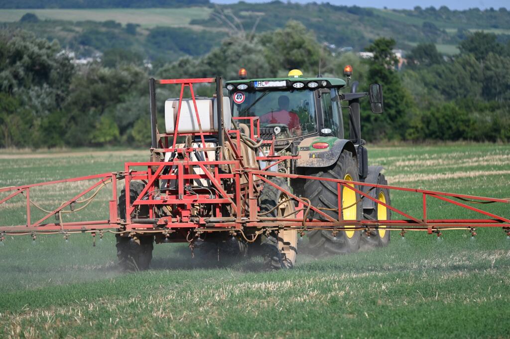 Na snímke traktor s prívesom na postrek na poli pri Hlohovci v utorok 15. augusta 2023. FOTO TASR - Lukáš Grinaj