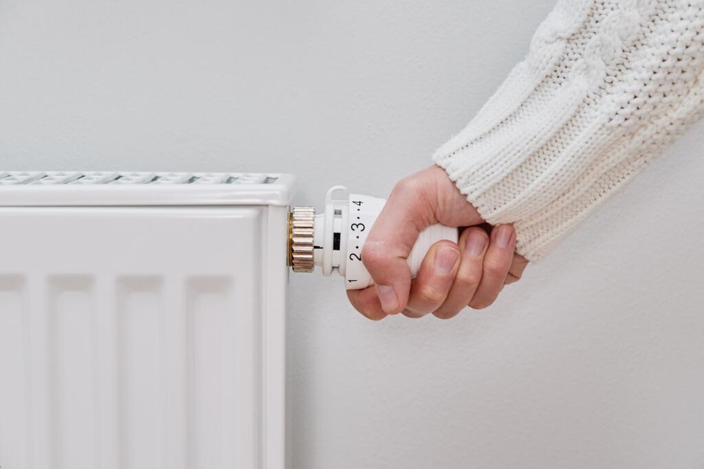 Woman,Adjusting,Temperature,On,Heating,Radiator,,Energy,Crisis,Concept,In
