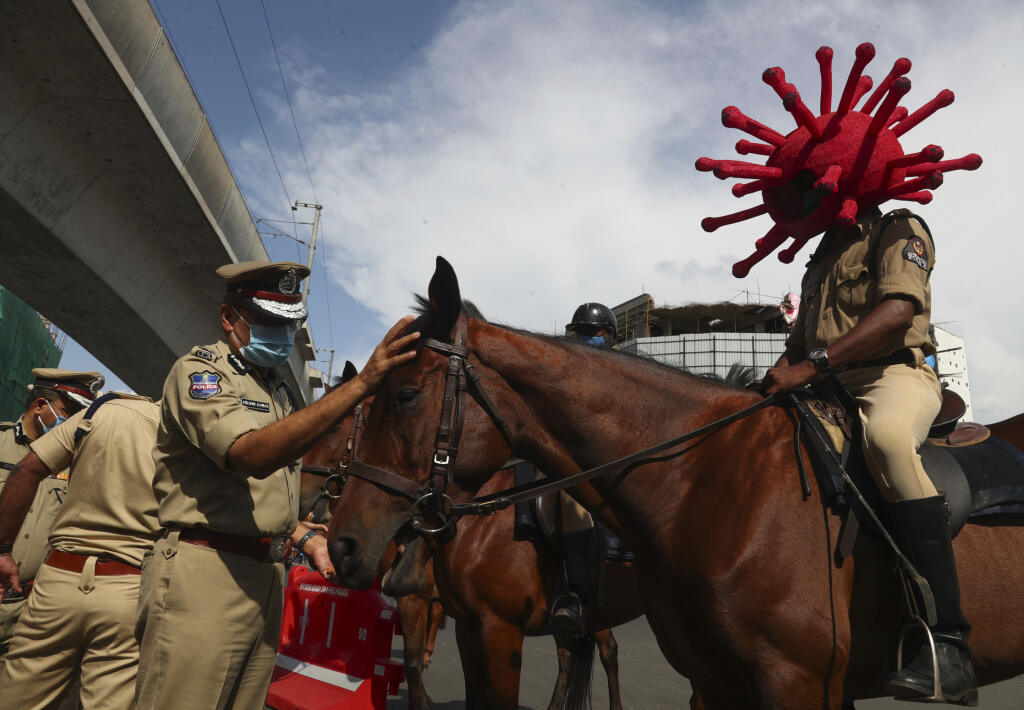 Príslušník jazdeckej polície s helmou v tvare nového koronavírusu jazdí v uliciach indického mesta Hajdarabád v utorok 1. júna 2021
A policeman rides a horse wearing a virus-themed helmet during a COVID-19 awareness drive in Hyderabad, India, Tuesday, June 1, 2021. (AP Photo/Mahesh Kumar A.)
