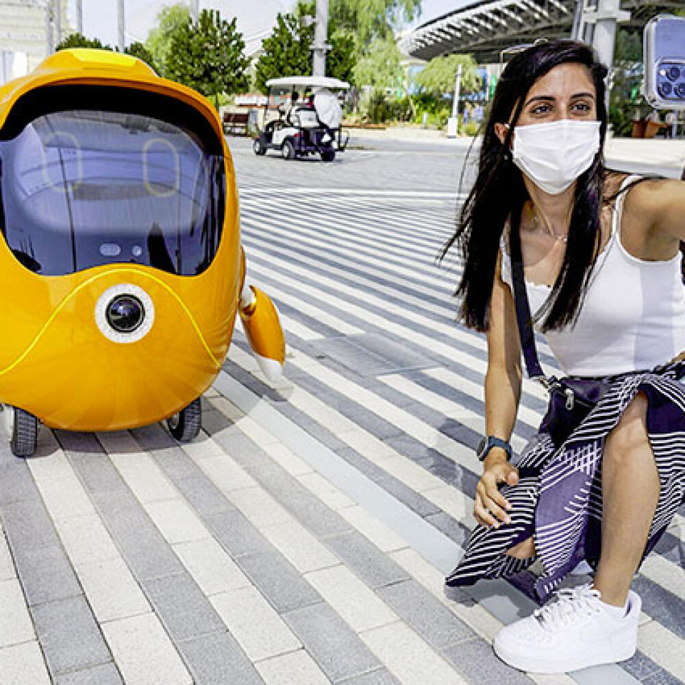 Návštevníčka sa fotí s maskotom Expa – robotom Optim.