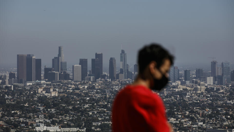 Dvadsaťročný Izzy Galvan s ochranným rúškom si užíva výhľad na centrum amerického mesta Los Angeles z Griffithovho observatória v stredu 15. júla 2020.