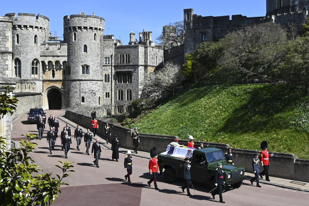 Britský princ Charles (vpredu vľavo), princezná Anne, princ Andrew. princ Edward, princ William, Peter Phillips, princ Harry, Tim Laurence a britská kráľovná Alžbeta II. v aute vzadu sprevádzajú rakvu pri prechádzaní okolo veže Round Tower počas pohrebu britského princa Philipa..