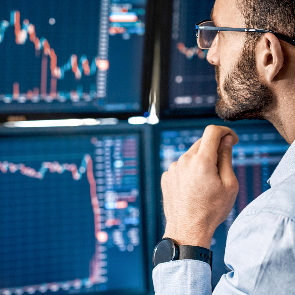Bearded,Man,Trader,Wearing,Eyeglasses,Sitting,At,Desk,At,Office,investovanie