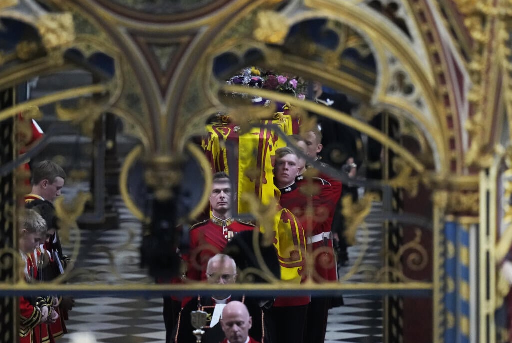 Rakvu s pozostatkami zosnulej britskej kráľovnej Alžbety II. vynášajú po skončení štátneho pohrebu z Westminsterského opátstva v Londýne v pondelok 19. septembra 2022.