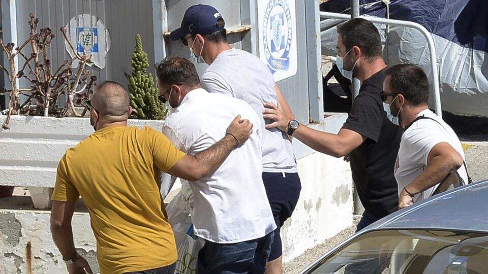 WA 20 Syros - Kapitán anglického futbalového klubu Harry Maguire (uprostred so šiltovkou) prichádza v sprievode policajtov v civile na policajnú stanicu na gréckom ostrove Syros v piatok 21. augusta 2020. Maguire skončil na gréckom ostrove Mykonos v putách miestnej polície. Stalo sa tak vo štvrtok v skorých ranných hodinách po incidente pred jedným z miestnych barov. Maguire sa podľa britských médií dostal do roztržky s ďalšími anglickými turistami a potom sa správal agresívne a vulgárne aj voč
