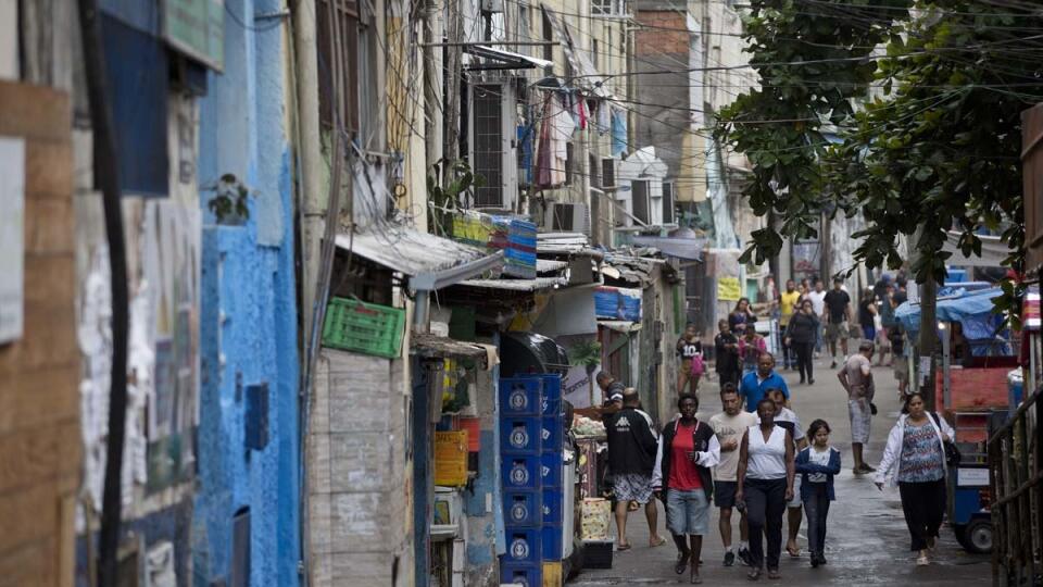 KK17 Rio de Janeiro - Na snímke ľudia kráčajú v slume Rocinha 24. októbra 2017 v Riu de Janeiro. Brazílska polícia pri akcii v jednej z chudobných štvrtí v Riu de Janeiro omylom zastrelila turistku zo Španielska. Policajti sa v pondelok vo favele Rocinha pokúsili zastaviť motorové vozidlo so šiestimi turistami. Keďže vodič okamžite nezastavil, začali strieľať. Zranená turistka, ktorú previezli do nemocnice, tam skonala vo veku 67 rokov. FOTO TASR/AP
Residents walk on one of the entrances of the