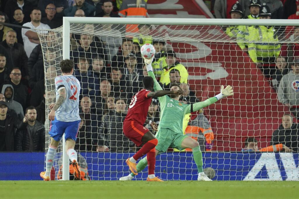 Brankár Manchesteru United David de Gea (vpravo) bráni pred Sadiom Maneom z Liverpoolu (druhý sprava) vo futbalovom zápase anglickej ligy Premier League FC Liverpool - Manchester United v Liverpoole 19. apríla 2022.