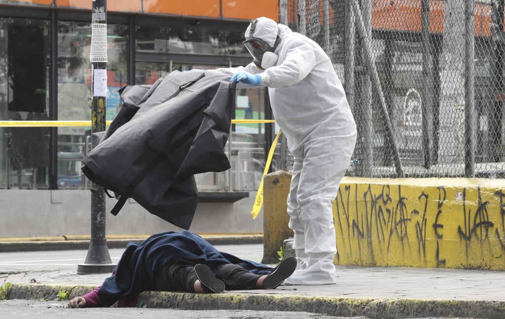 WA 1 Quito - Forenzný technik prikrýva telo mŕtvej ženy, ktorá skolabovala na ulici v hlavnom ekvádorskom meste Quito vo štvrtok 14. mája 2020. FOTO TASR/AP  

A worker from the city's forensic department, wearing full protection gear against the new coronavirus, covers the body of a woman who collapsed and died on a street in Quito, Ecuador, Thursday, May 14, 2020. Forensic workers at the scene conducted a COVID-19 rapid test and determined that the woman did not die from the virus. (AP Photo/D
