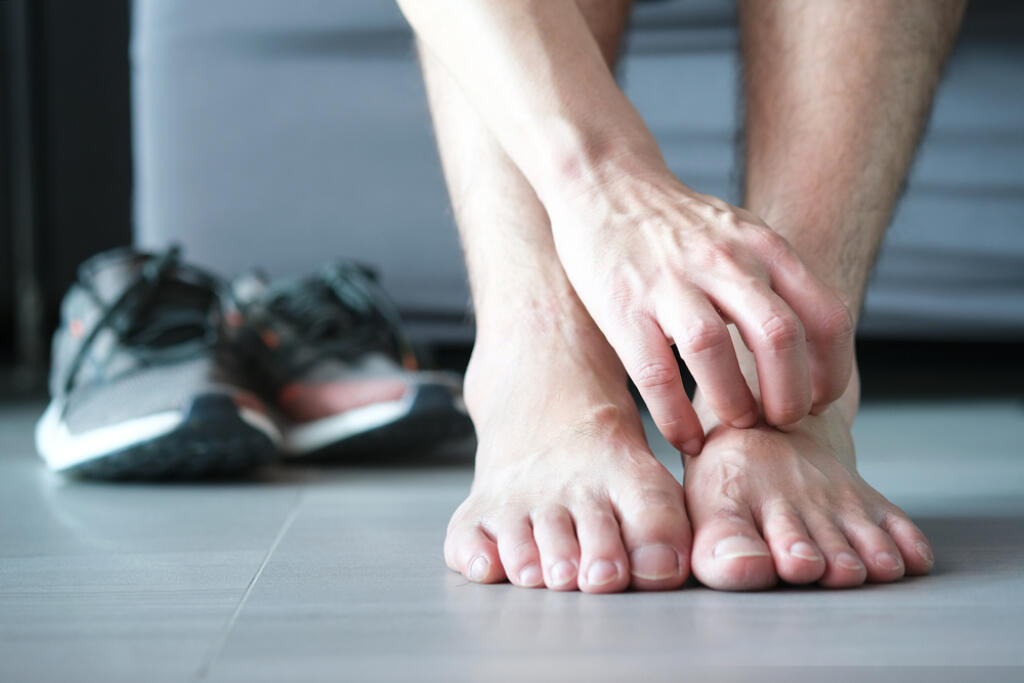 Men,Wear,Canvas,Shoes,,He,Scratches,Legs,And,Feet,With